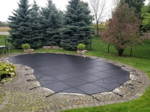Black safety cover on an oval swimming pool