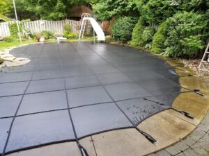 Swimming pool with a black safety cover