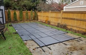 Rectangular pool with a grey safety cover