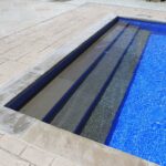 Blue beach pebble liner installed on a pool